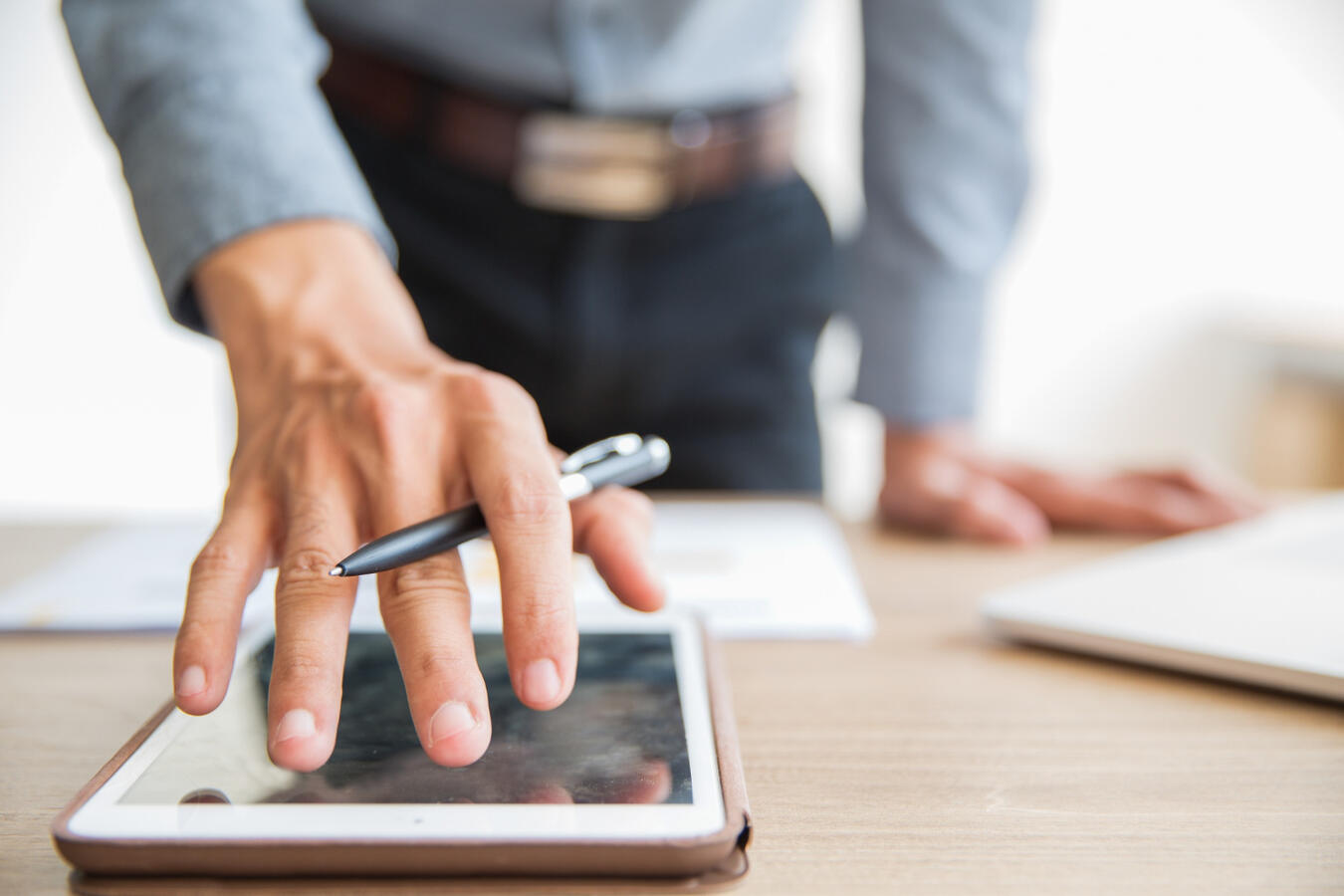 A professional holds an e-pen over a tablet