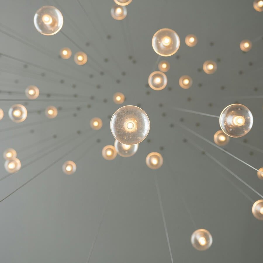 Yellow lightbulbs hang from a ceiling