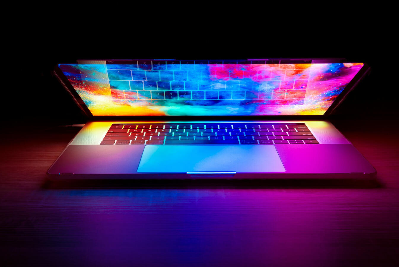 A laptop with a colorful screen that's halfway closed